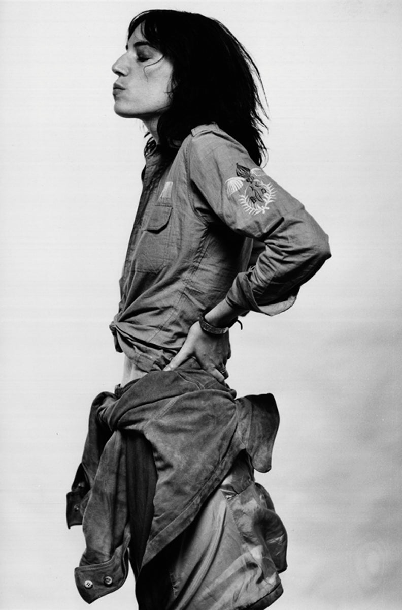 Patti Smith standing in profile with one hand at her hip in 1976. Photograph by Gijsbert Hanekroot.