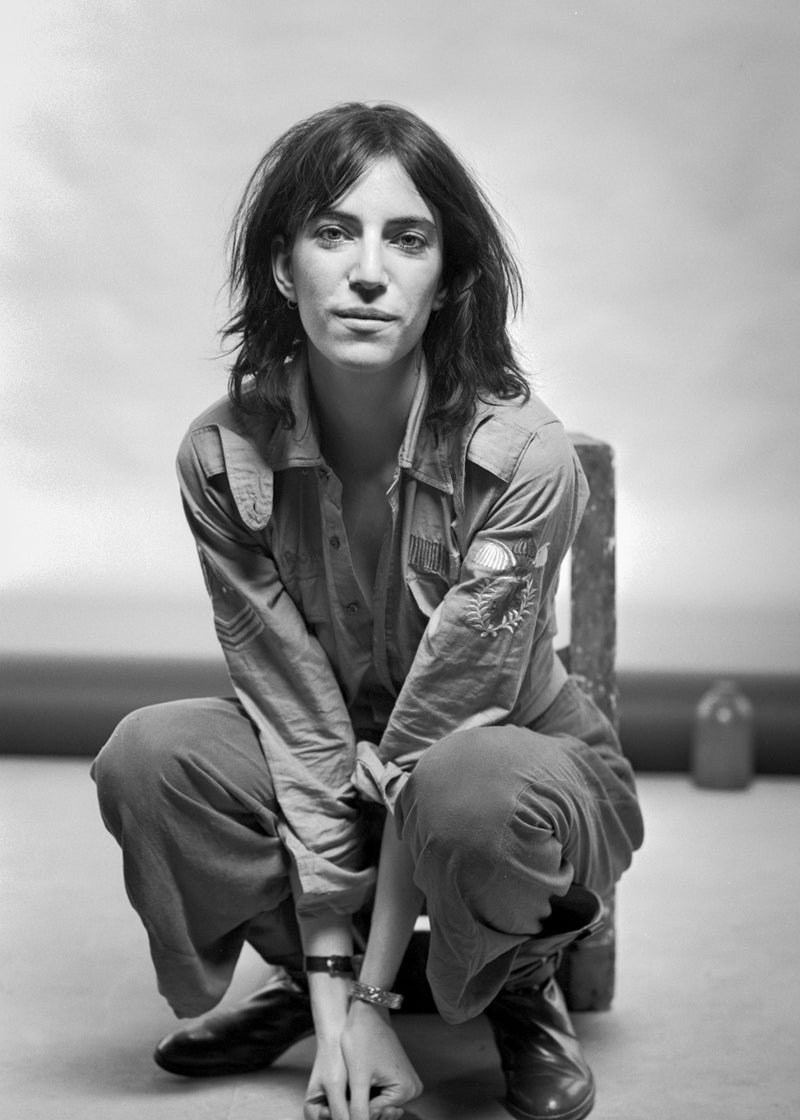 Patti Smith seated and facing the camera in a full-length portrait in 1976. Photograph by Gijsbert Hanekroot.