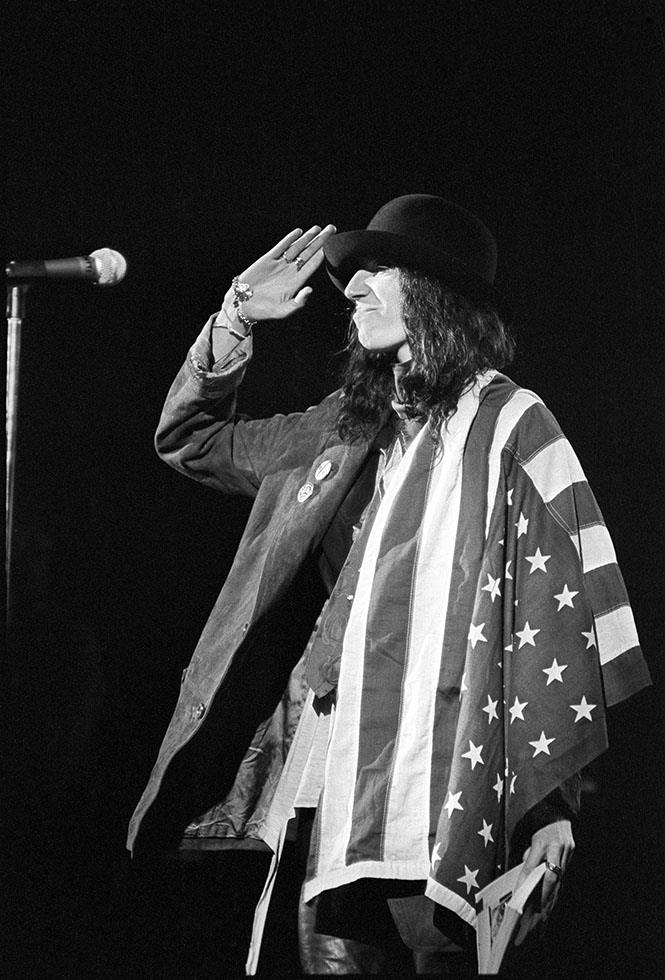 Patti Smith draped in the American flag on stage, photographed by Charlyn Zlotnik, 1978.