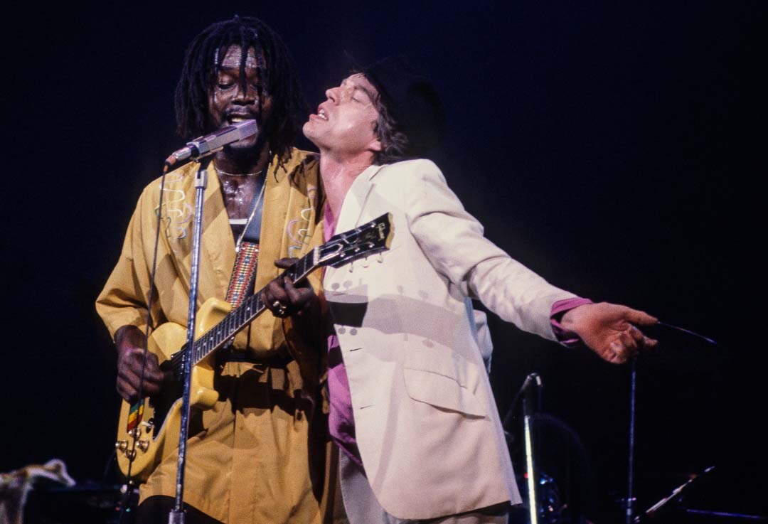 Peter Tosh and Mick Jagger sharing a stage, in color, 1978, photographed by Lynn Goldsmith.