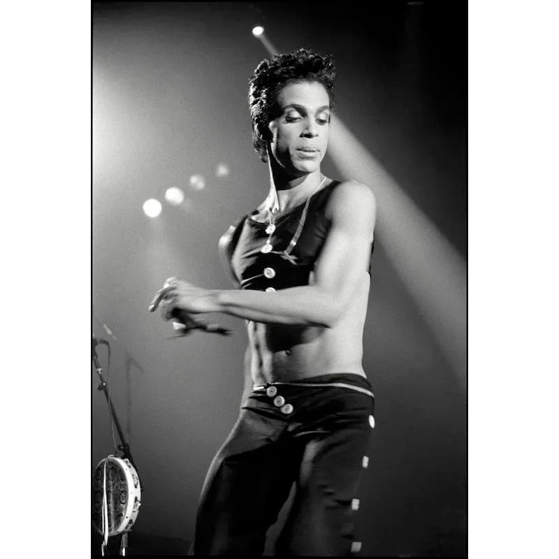 Prince performing on stage in a sleeveless outfit at Wembley Arena, London, in 1986, photographed by David Corio.
