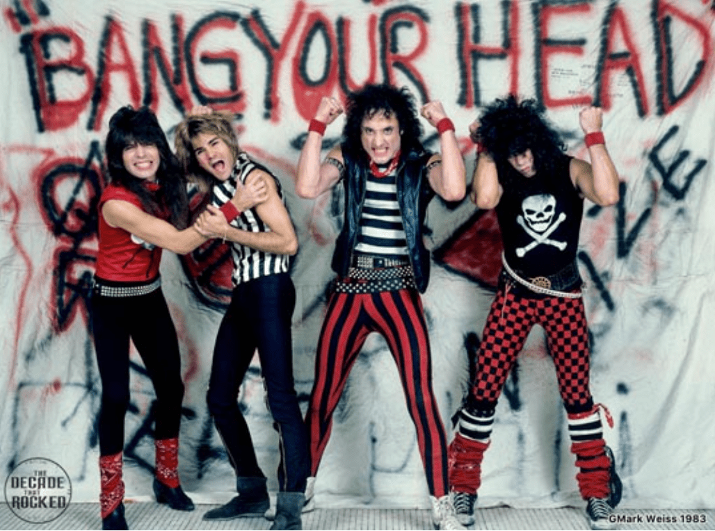 Quiet Riot photographed in front of a Bang Your Head backdrop, 1983, by Mark Weiss.