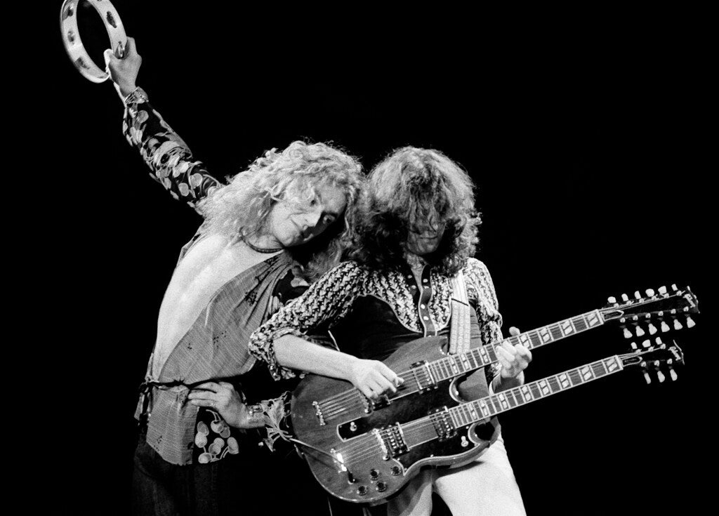 Robert Plant with a tambourine beside Jimmy Page on double-neck guitar, 1975, photographed by Lynn Goldsmith.