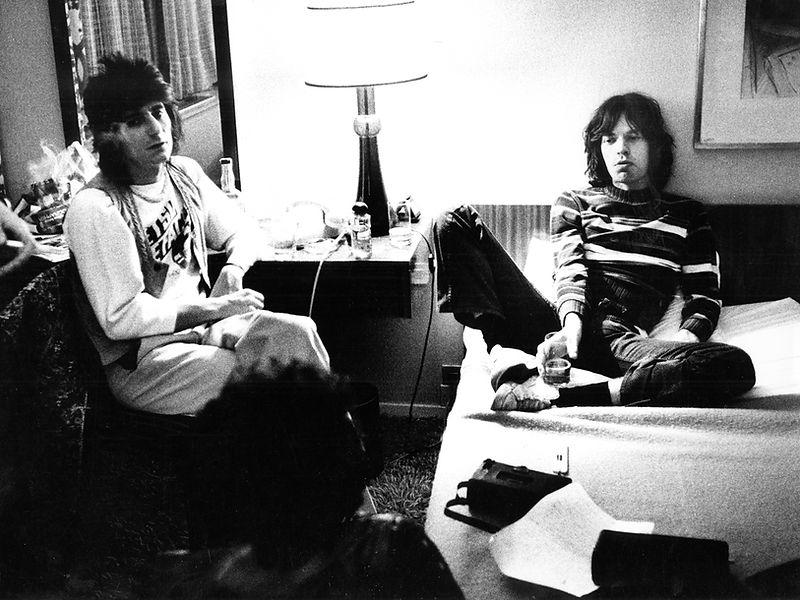 Members of The Rolling Stones seated in conversation in an interior in 1976. Photograph by Gijsbert Hanekroot.
