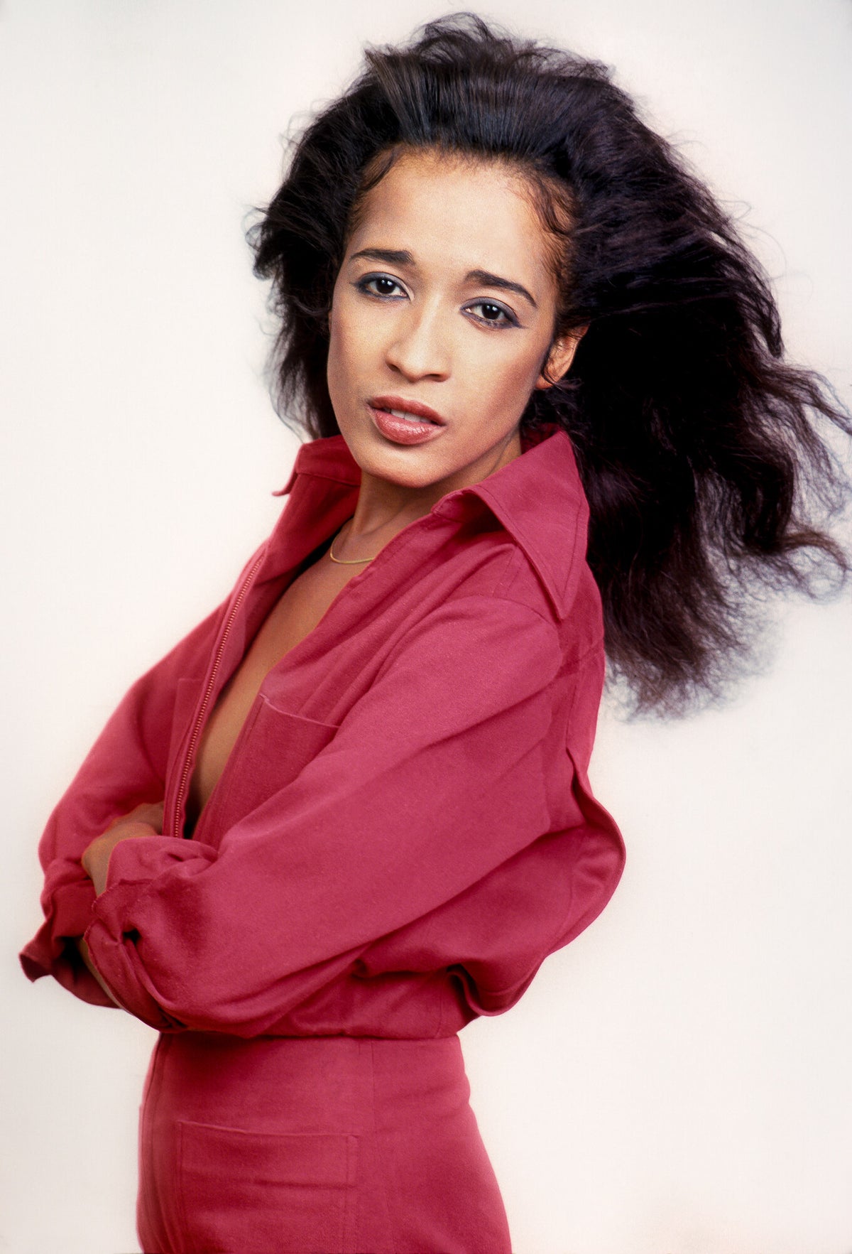 Ronnie Spector in a red dress against white, in color, 1977, photographed by Lynn Goldsmith.