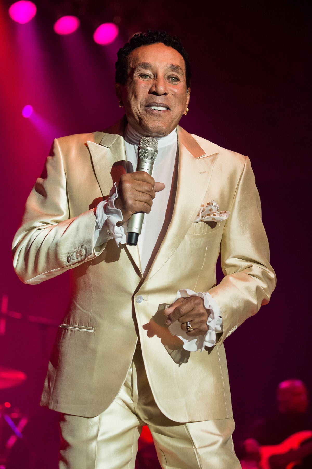 Smokey Robinson singing in a cream satin suit, in color, 2016, photographed by Lynn Goldsmith.