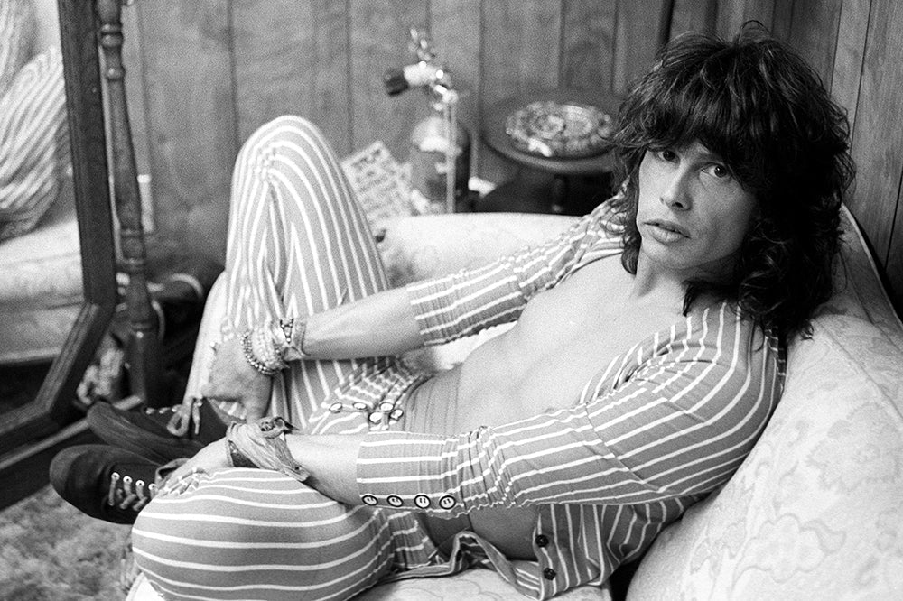 Steven Tyler of Aerosmith reclining on a couch during the Done With Mirrors Tour, Arizona, 1985, photographed by Mark Weiss.