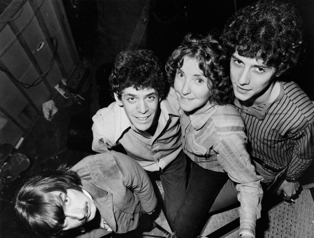 The Velvet Underground in a tight group portrait, leaning in toward the camera, 1966, photographed by Lynn Goldsmith.