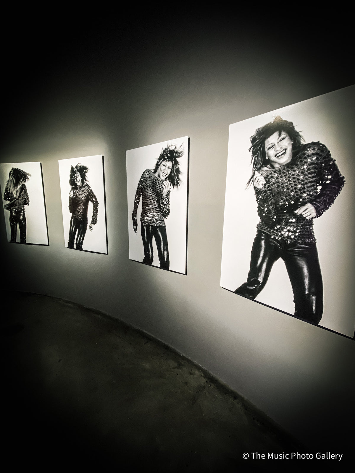 Four black-and-white portraits of Tina Turner installed along a curved wall in Tina Turner: A Journey to the Future at the Museum of Image and Sound (MIS), São Paulo, Brazil.