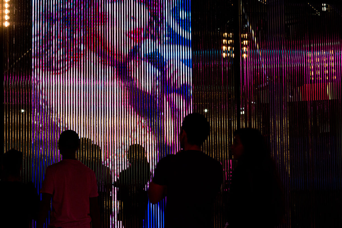 Visitors in front of a video installation seen through a curtain of metallic strands in Tina Turner: A Journey to the Future, Museum of Image and Sound (MIS), São Paulo, Brazil.